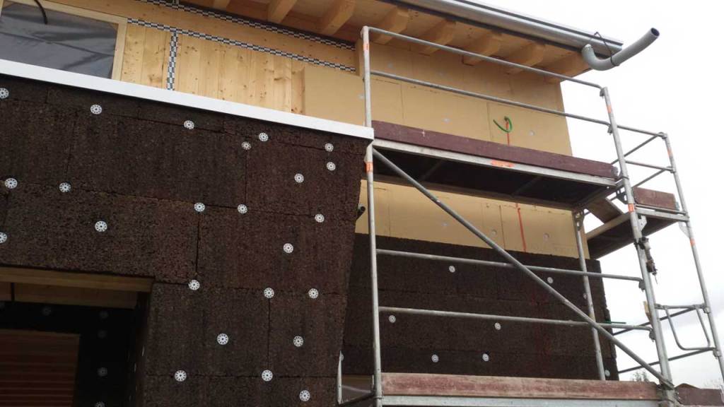 Ecologia del costruire: costruire in legno o con un po’ di legno? Isolamenti a cappotto con sughero e fibra di legno coerenti con una casa in legno Foto Holzius
